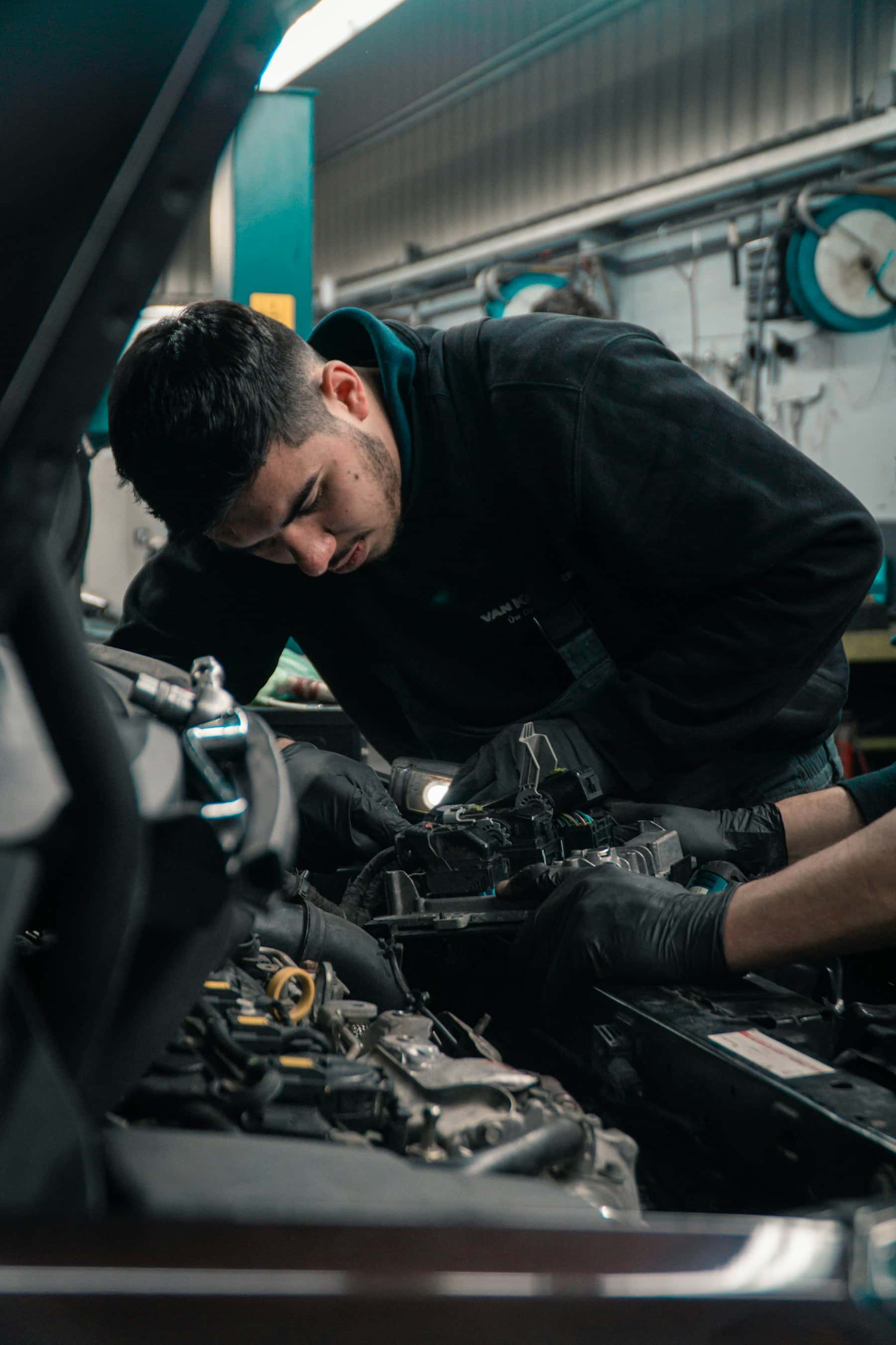 Mechanic working on a car engine in a garage
