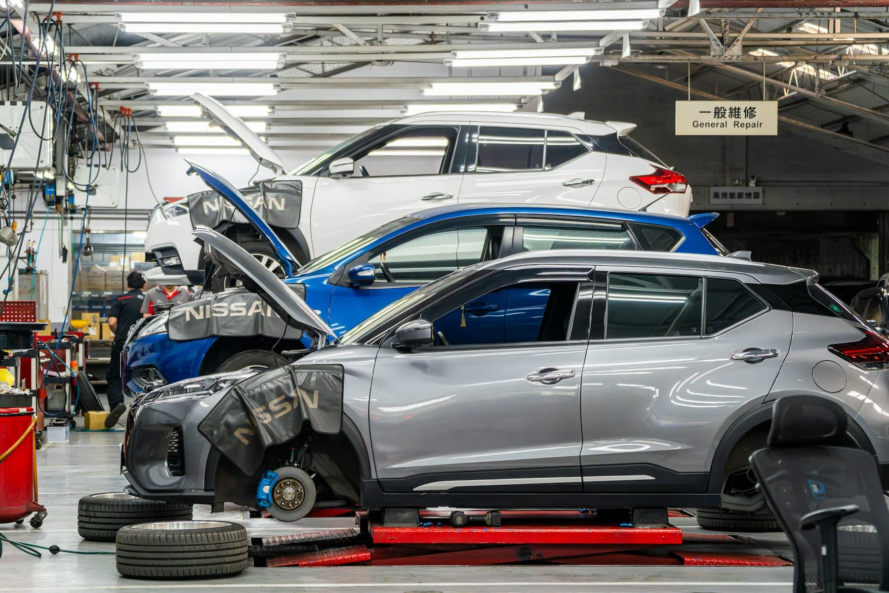 Cars up on lifts being repaired in a workshop
