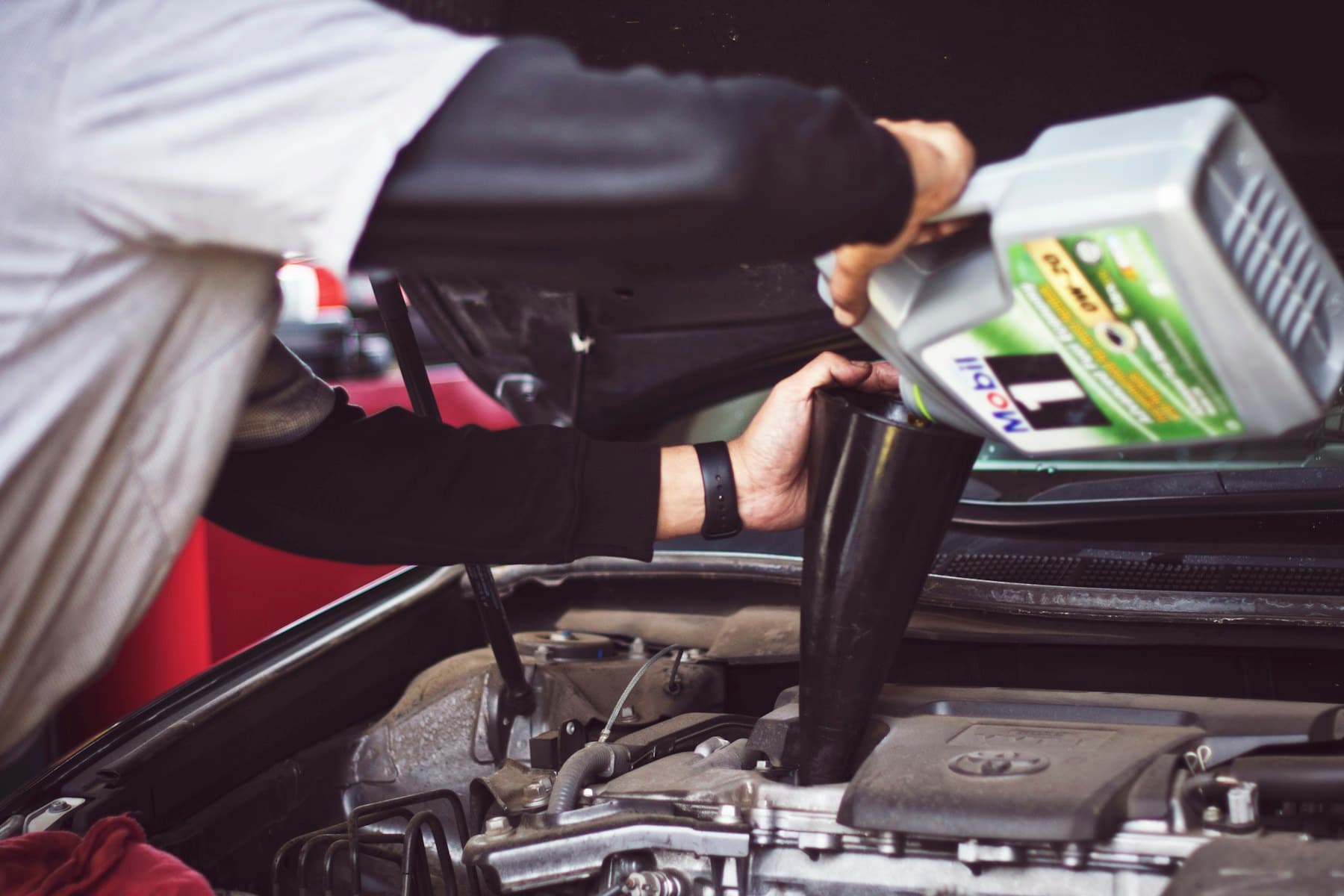 Mechanic topping up engine oil