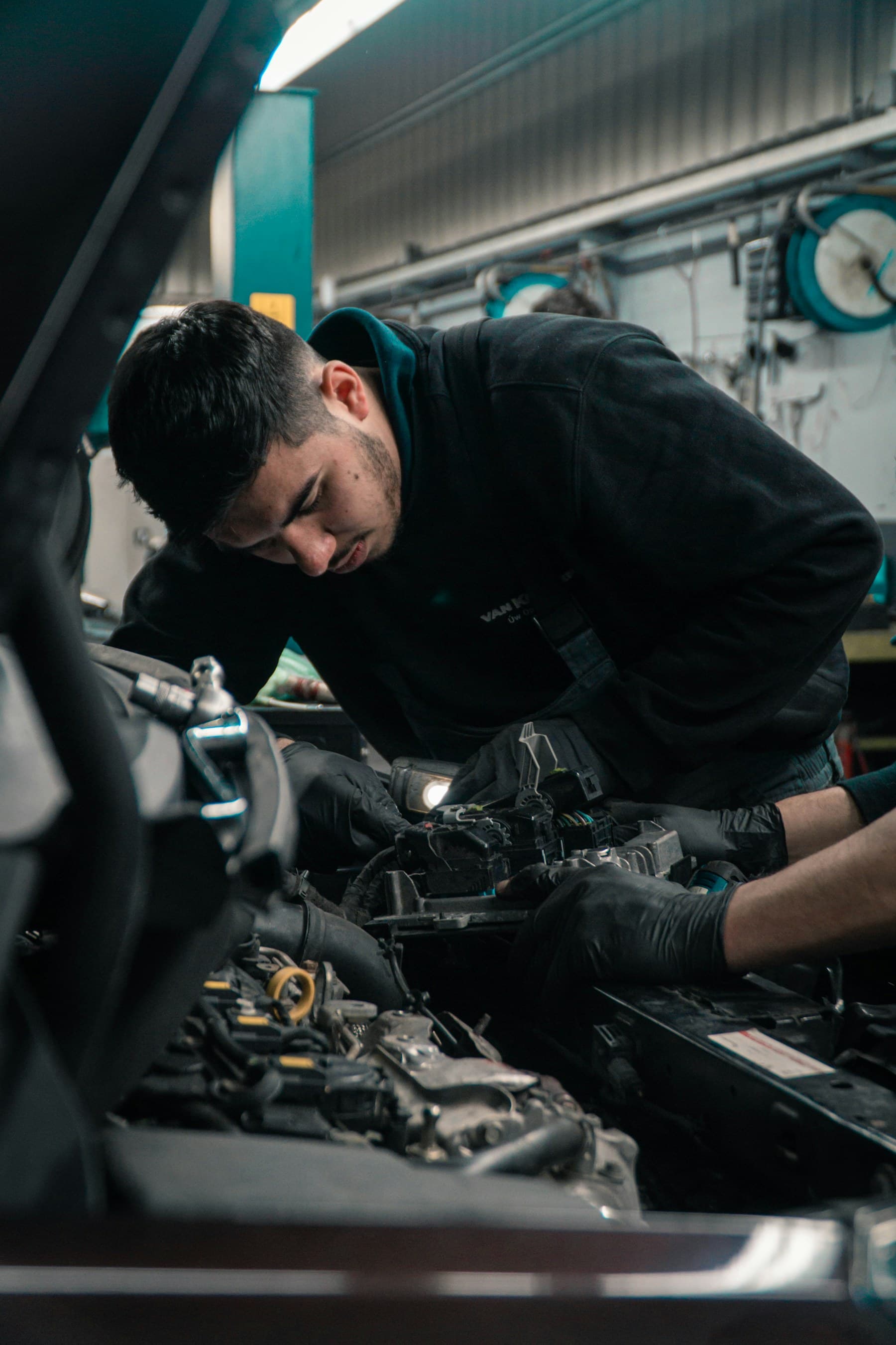 Mechanic working on a car engine in a garage